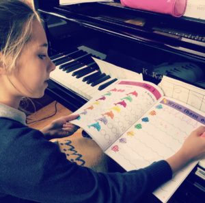 A student using the workbook pages in the Cascade Method Piano Theory Book