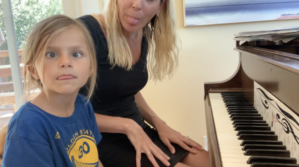 teacher with young student playing the piano 