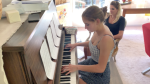 Piano teacher watching student rehearse her playlist as a warmup exercise, piano training tip