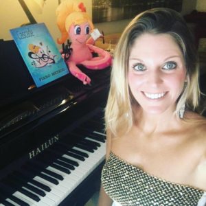 Tara Boykin, the piano influencer that teaches how to keep piano alive in the 21st century, standing next to her piano with her piano theory book