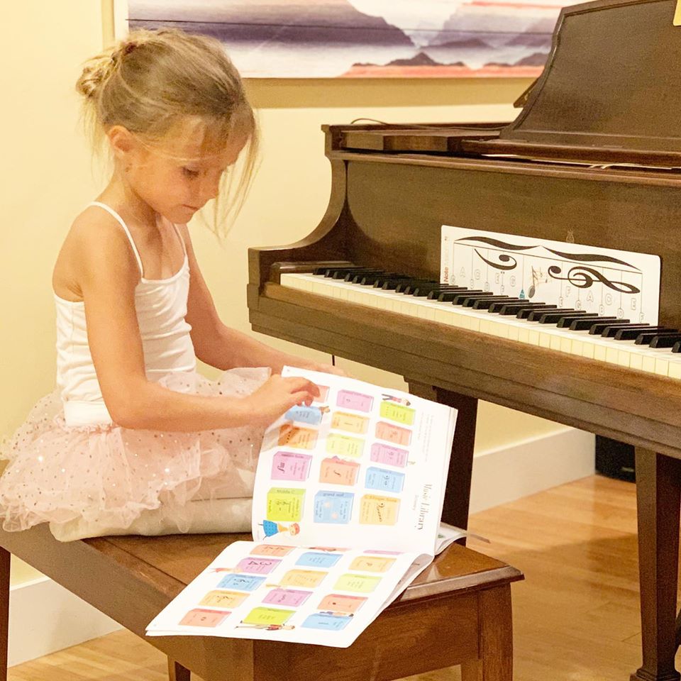 Young girl shuffling through sheet music deciding which piece to play next