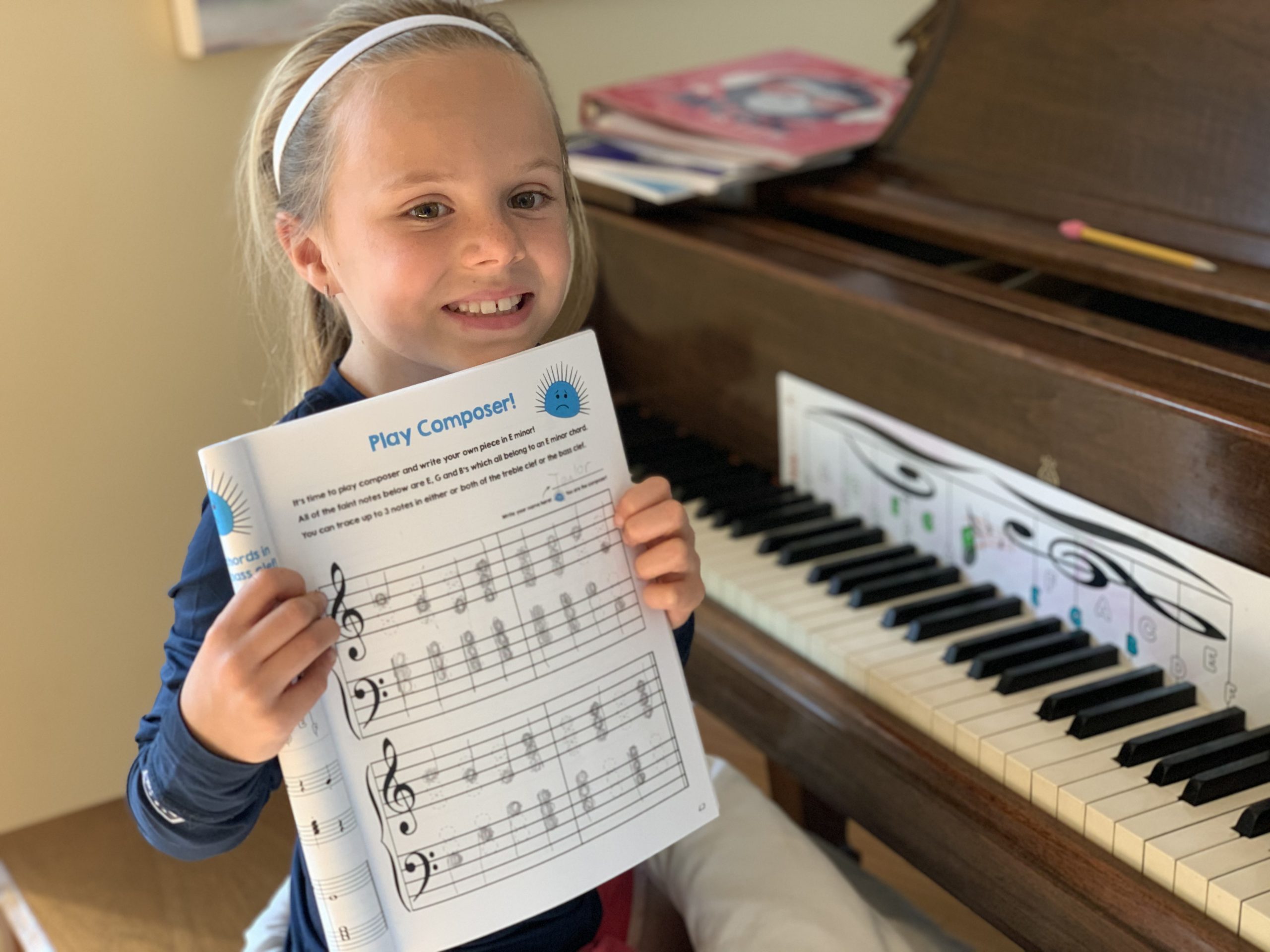 Piano student showing off her completed composer page in the Cascade Method Chords 1 Book