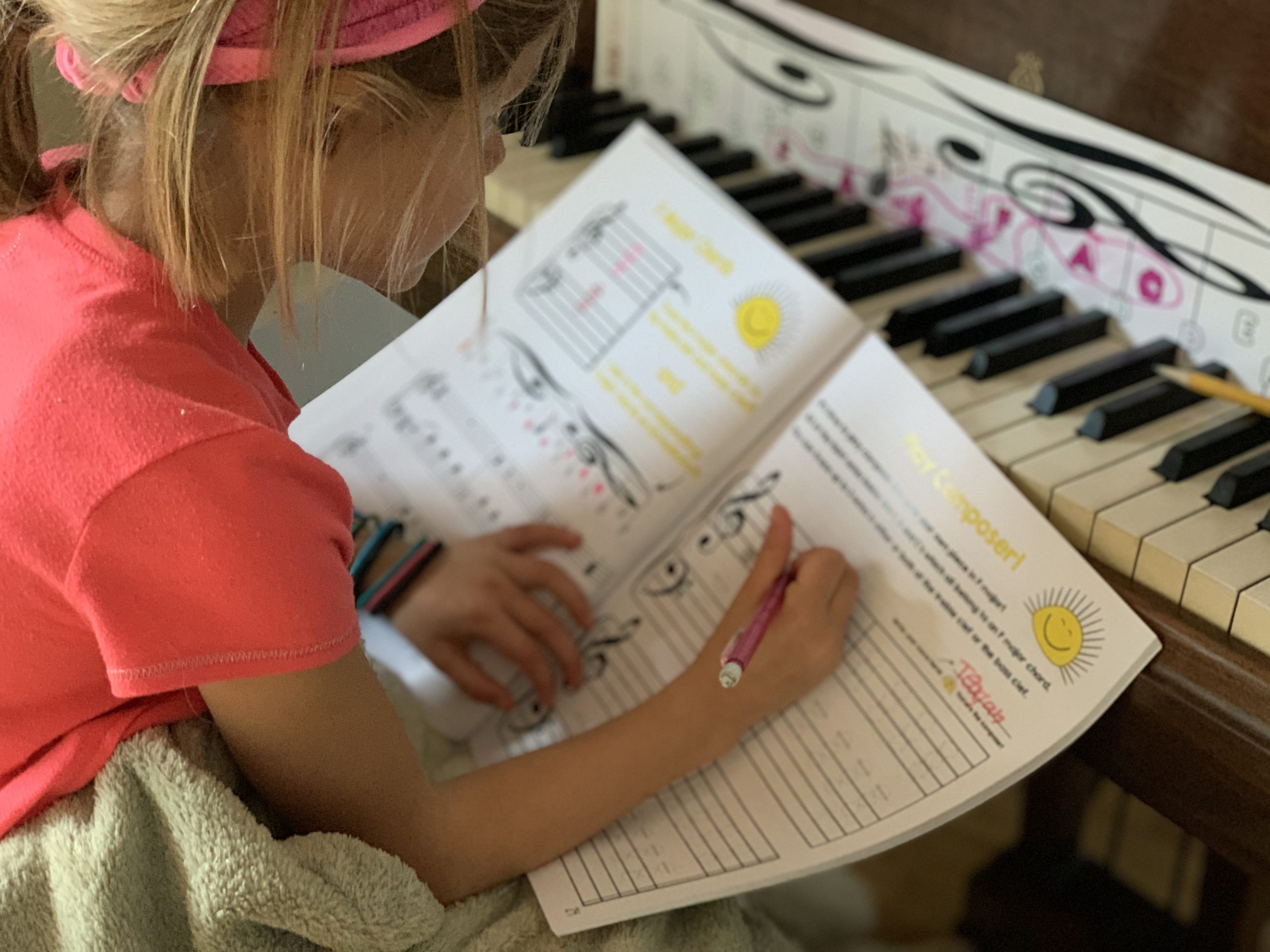 A student filling out the Play Composer Sheet in the Chords 1 Piano Workbook